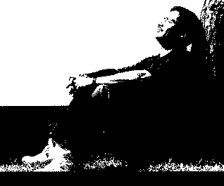 A man sitting against a tree, praying